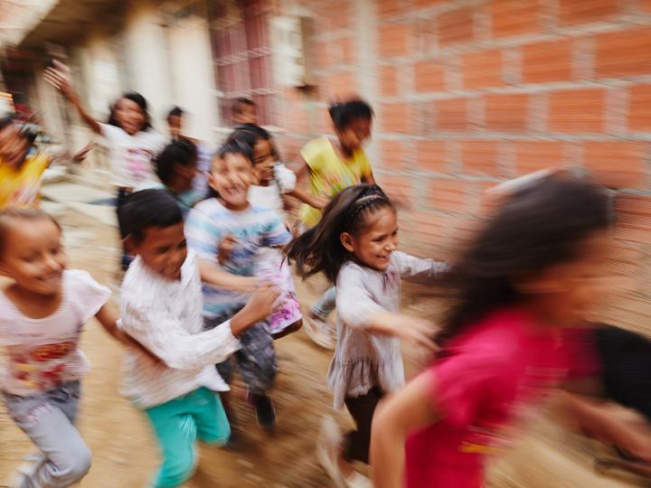 A group of children run in Colombia