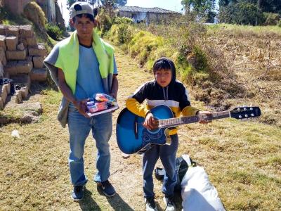 David in Peru plays his guitar given through World Vision