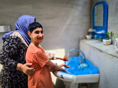 Suha* helping Harith with washing his hand and face. Dastan Sabah © World Vision 2024.