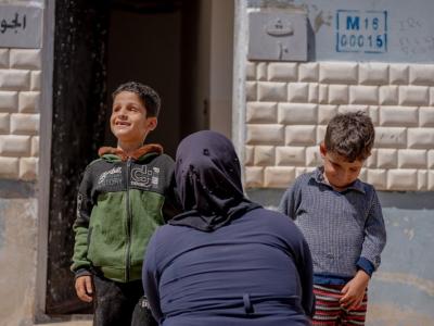 Um Khaled* with her children in front of her house  World Vision Syria Response - Zaher Jaber