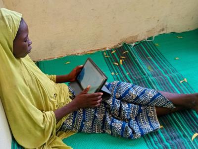 Little girl reading on a tablet in Chad.