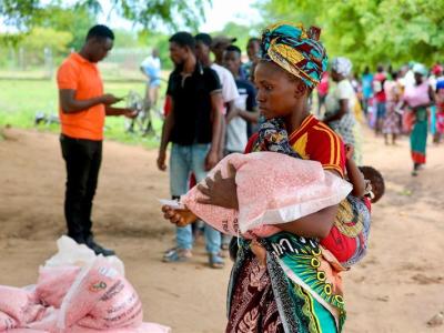 A mother with a her child in her back receives her portion of the seeds.