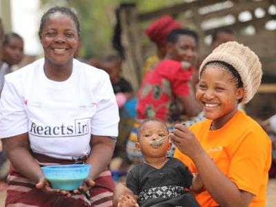 A health facilitator helping a mother feed her child. 