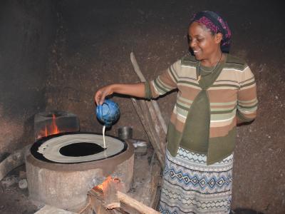 Fikirte making injera in cookstove