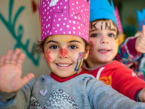 Children with face paint wearing crowns