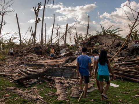 A family in the Philippines surveys the devastation of Typhoon Haiyan