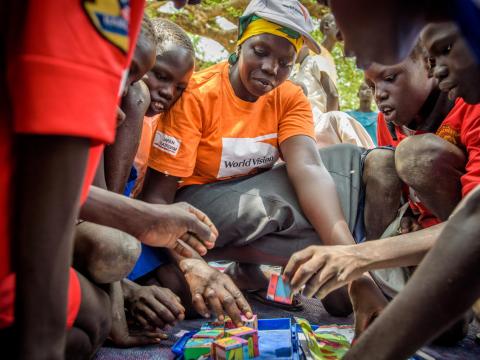 World Vision staff playing a game with children