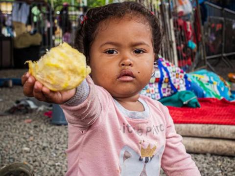 Child with food in their hands part of World Vision's emergency health and nutrition programmes