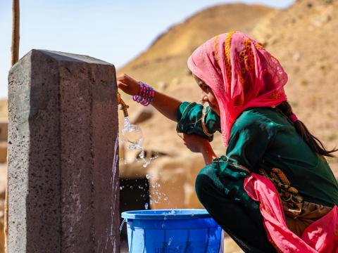 A young girl in Afghanistan collects water from a tap built with support from UNICEF