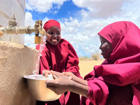 Girls in Kenya whose community is facing intense drought collect water trucked in by World Vision