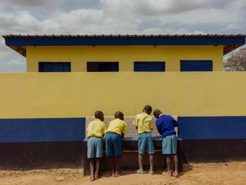 Children in Kenya wash their hands at a sanitary point installed at their school