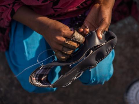 Kanya (12) stitches shoes at her home in Agra, India