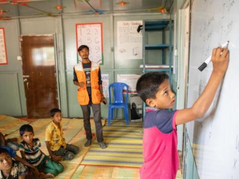 Boy writing on white board