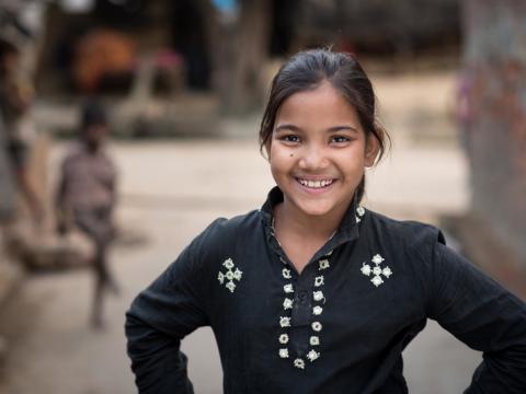 Preeti standing near her home in India