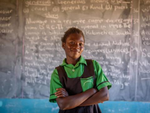 Felistus standing in front of the board in classroom