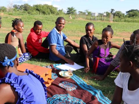 Young people sit around a bowl of savings