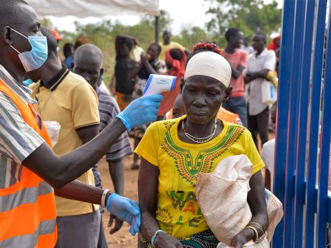  A volunteer checking beneficiary temperatures 