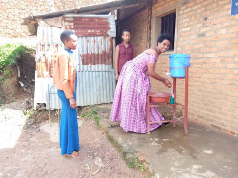 Chantal washes her hands as her little sisters look on