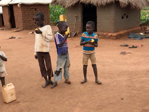 Children from Bidibidi settlement eating mangoes