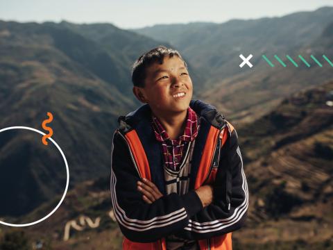 Sponsored child, Chenglong 10 sits with the rolling hills of Wudang in the background.