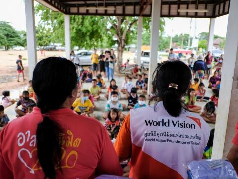 world Vision staff sit next to partner