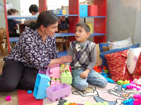 World Vision staff help child with disabilities