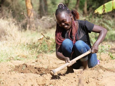 Ruth uses a hoe to prepare the ground 