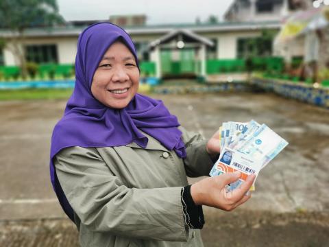 Lady showing money to the camera