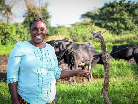 Agatha M with her cattle that she bought with World Vision help