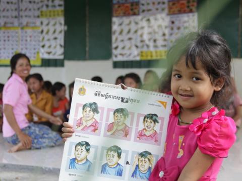 child holds up educational material