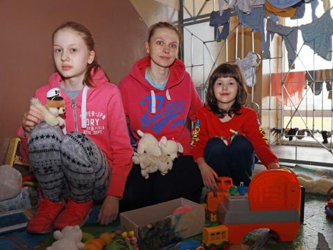 Children sit with their mother after being displaced by violence in Ukraine