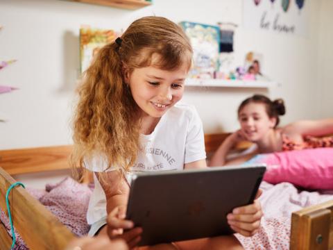 Child holds ipad