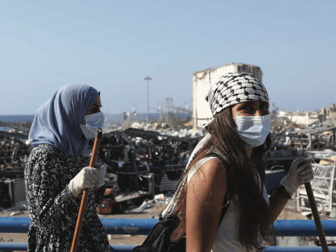 two women stand with a city skyline behind them