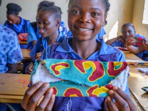 Girl in Zambia making sanitary pad as part of WASH UP programme