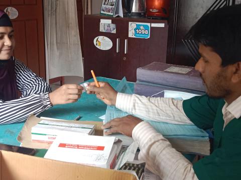 two people. a girl smiling as she receives medicine from a doctor