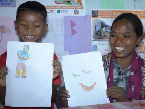 Biyes and his mother show the drawings they made together