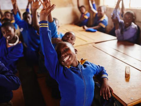 Children raising their hands in class