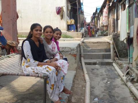 Girls sit in an urban context in India