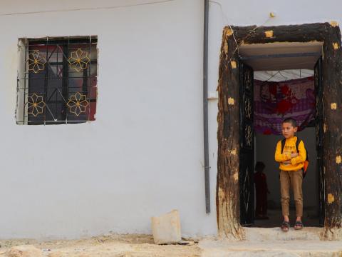 Badr happily holding in front of his house