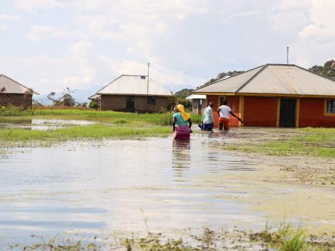 Flood-affected and displaced families walk through flood water in Migori County in Kenya