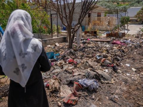 Qamar in front of her burnt tent 