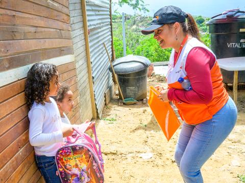 World Vision staff talking to two girls