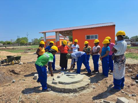 A group of women benefits from training facilitated by World Vision on how to build latrines.