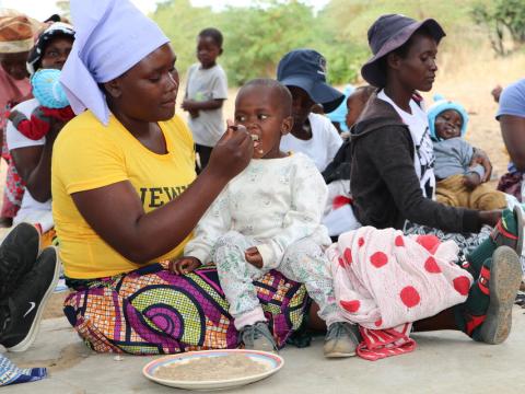 Mothers feeding their children during a PD Hearth session in Chisvo Village, Mudzi District