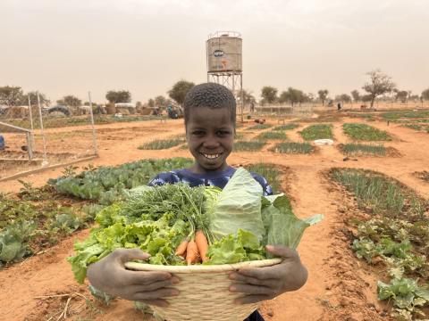 A young beneficiary happy with his harvest for the day