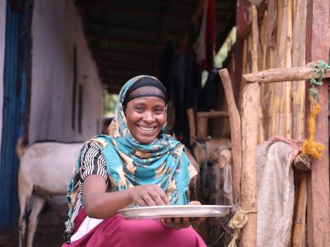 Sadia smiling while mixing and preparing flour