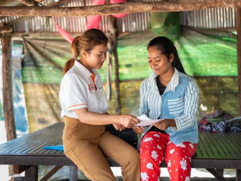 World Vision staff member talks with child in Cambodia