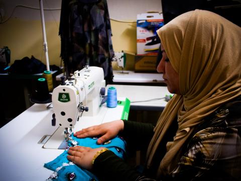 Ruwaida tailoring at her atelier within her apartment: Amna Falih, © World Vision 2024.