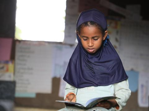 Anila reading a book at the Omo Nadda reading camp 