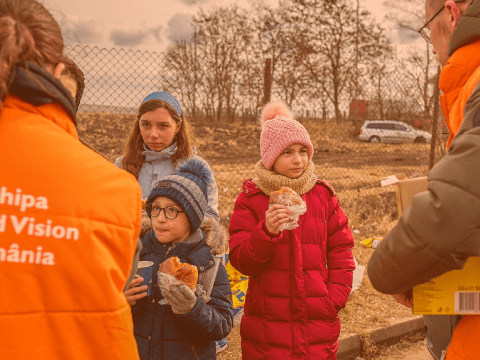 family stands receiving aid from WV workers